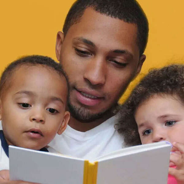 A dad reads to his two toddlers. Kindermusik’s literacy workshop helps teachers and families use the power of music to enhance storytime and increase early literacy skills.